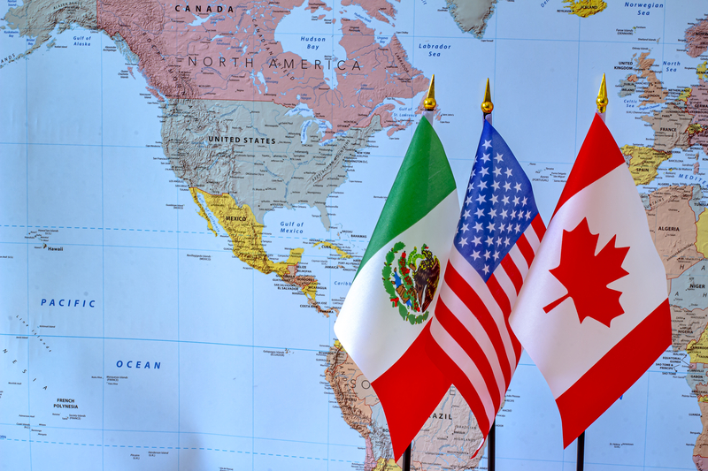 Canada-USA-Mexico flags in front of a map of the North America