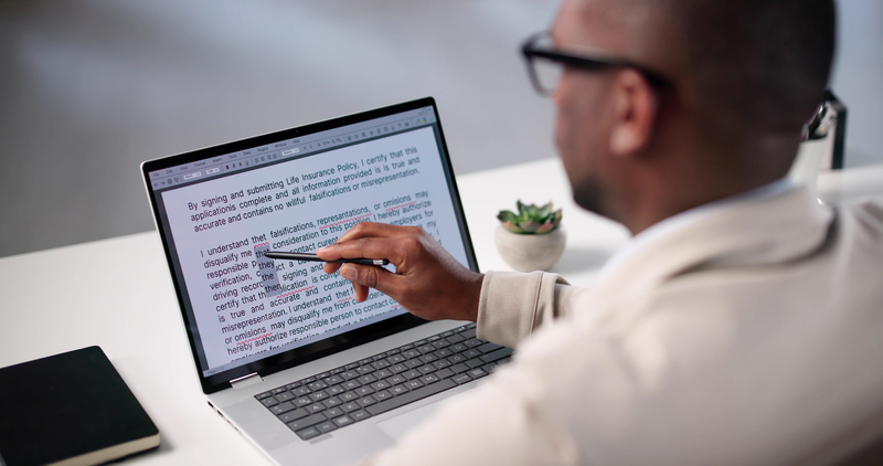 A business person editing a document on a laptop A business person editing a document on a laptop