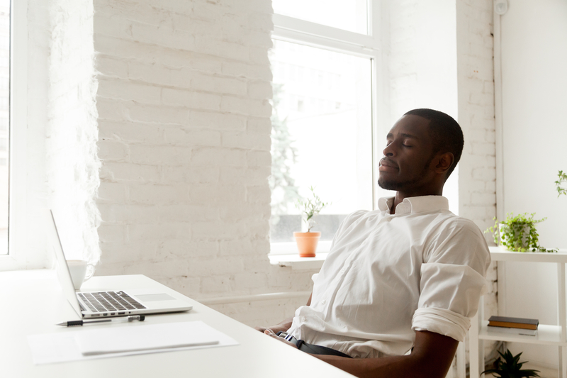 Solopreneur meditating with eyes closed for increasing productivity at workplace